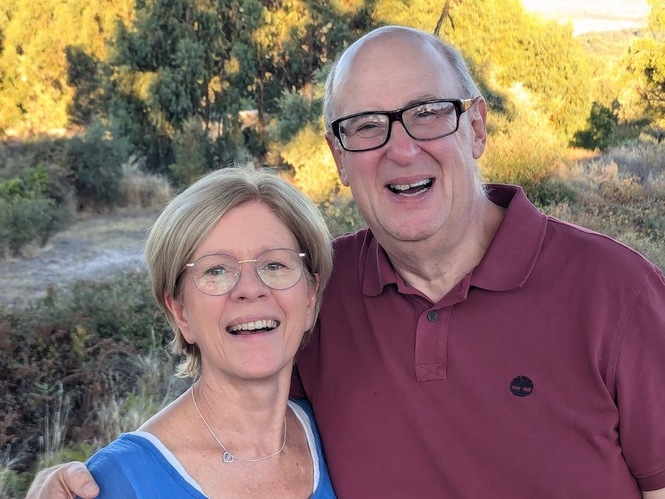 man and woman looking happy in front of green and yellow tree